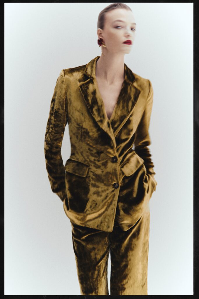 A fitted green velvet suit with a V-neckline and buttoned details.
