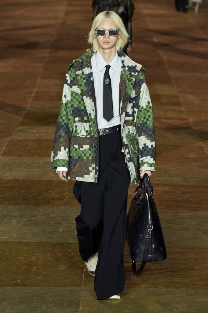 A relaxed fit green printed jacket with long sleeves paired with wide-leg black pants.