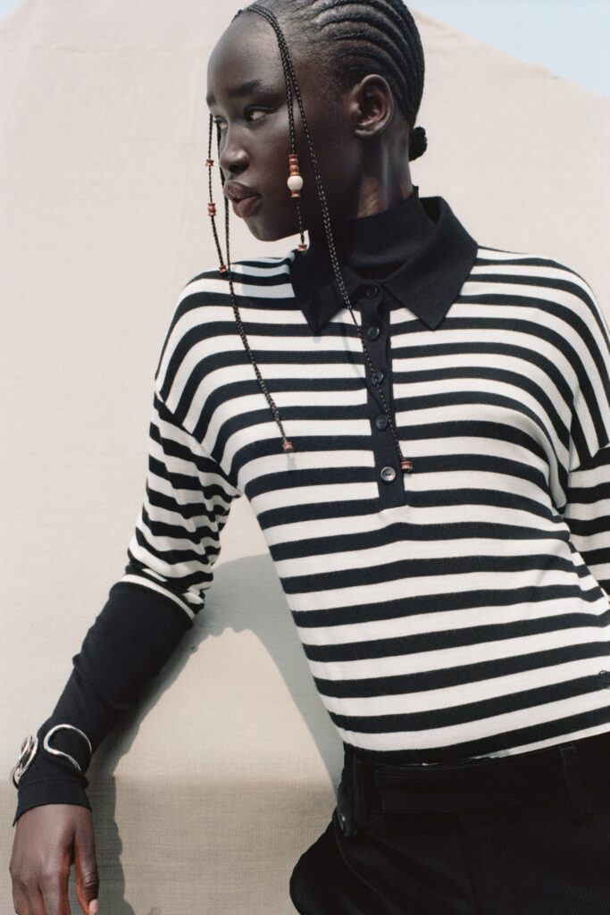 A fitted black and white striped long-sleeve top with a collared neckline.
