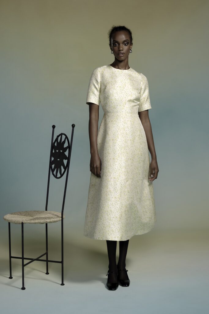 A fitted yellow silk dress with short sleeves and an A-line silhouette.