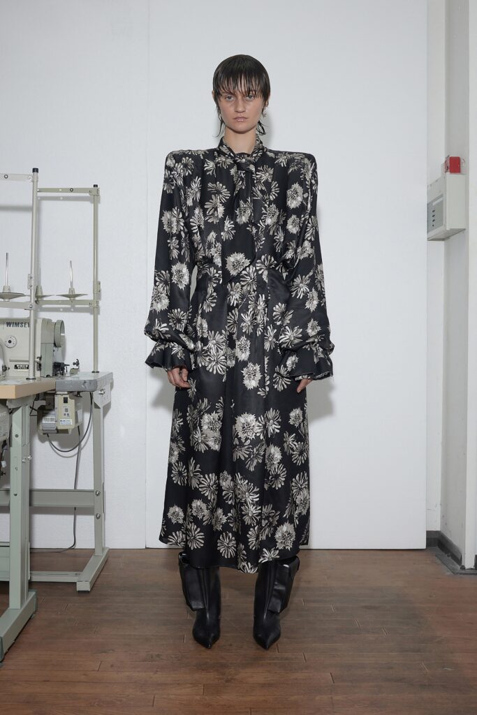 A relaxed black floral silk dress with long sleeves and a collared neckline.