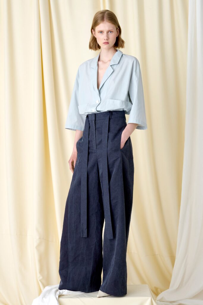 A relaxed blue cotton top with short sleeves paired with navy wide-leg pants.