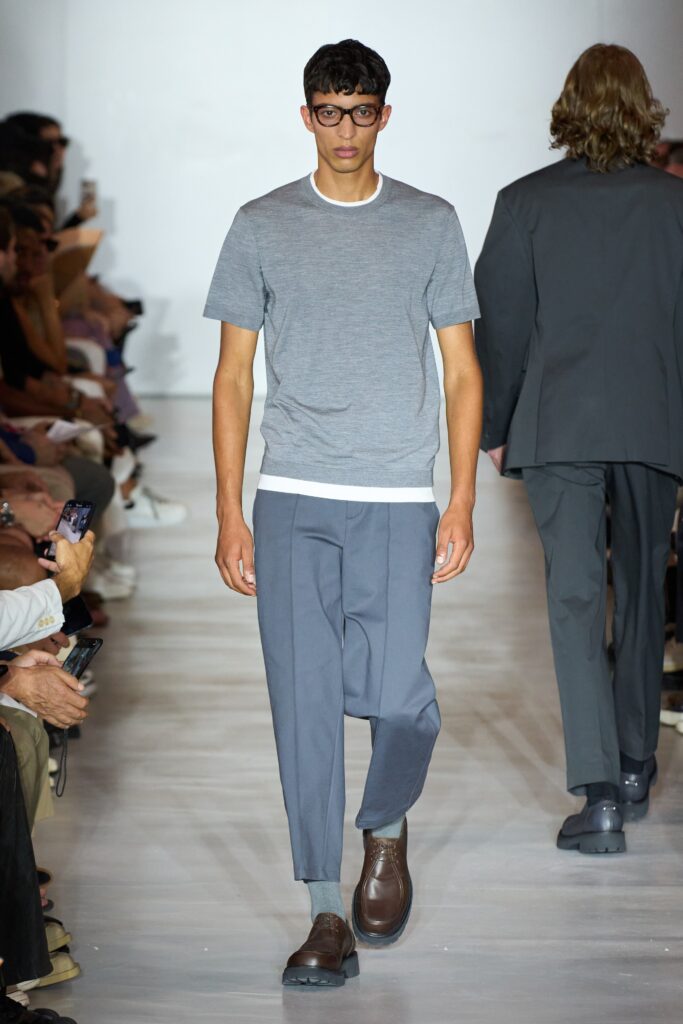 A relaxed gray cotton short-sleeve shirt paired with blue straight-leg pants.