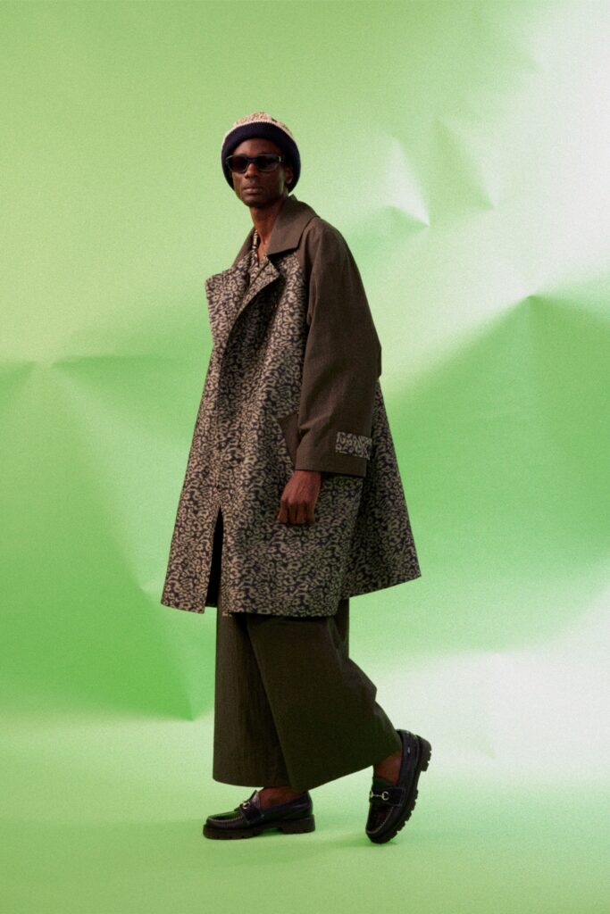 A relaxed green printed coat paired with wide-leg brown pants for a stylish look.