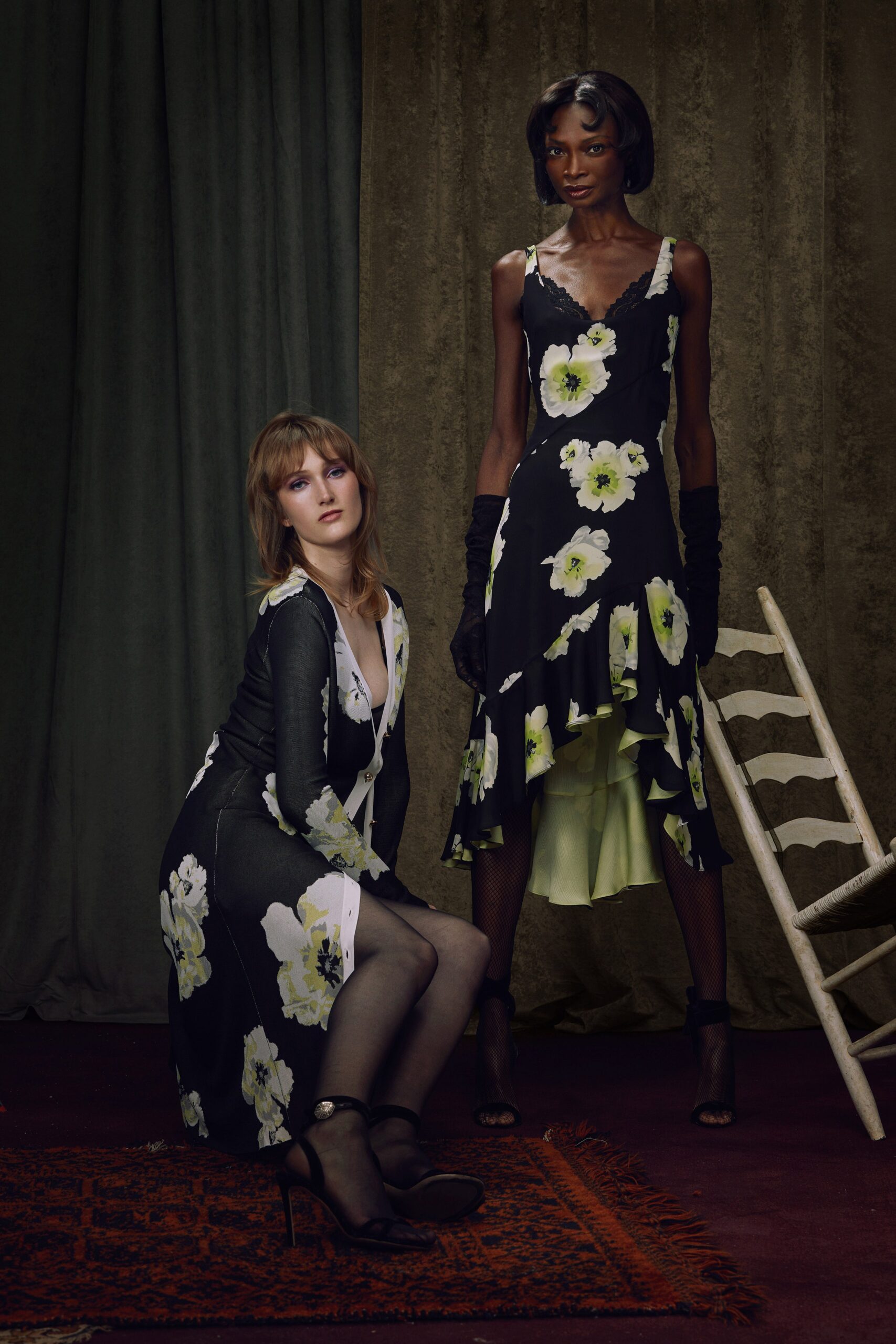A fitted black silk dress with a V-neckline and flared silhouette.
