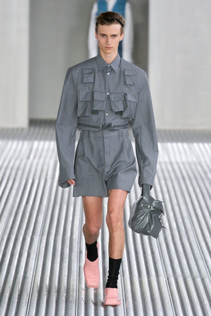 A fitted gray cotton shirt with short sleeves and pleated shorts, featuring a collared design.