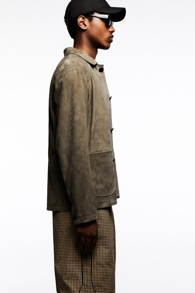 A relaxed brown suede jacket paired with checked pants for a contemporary look.