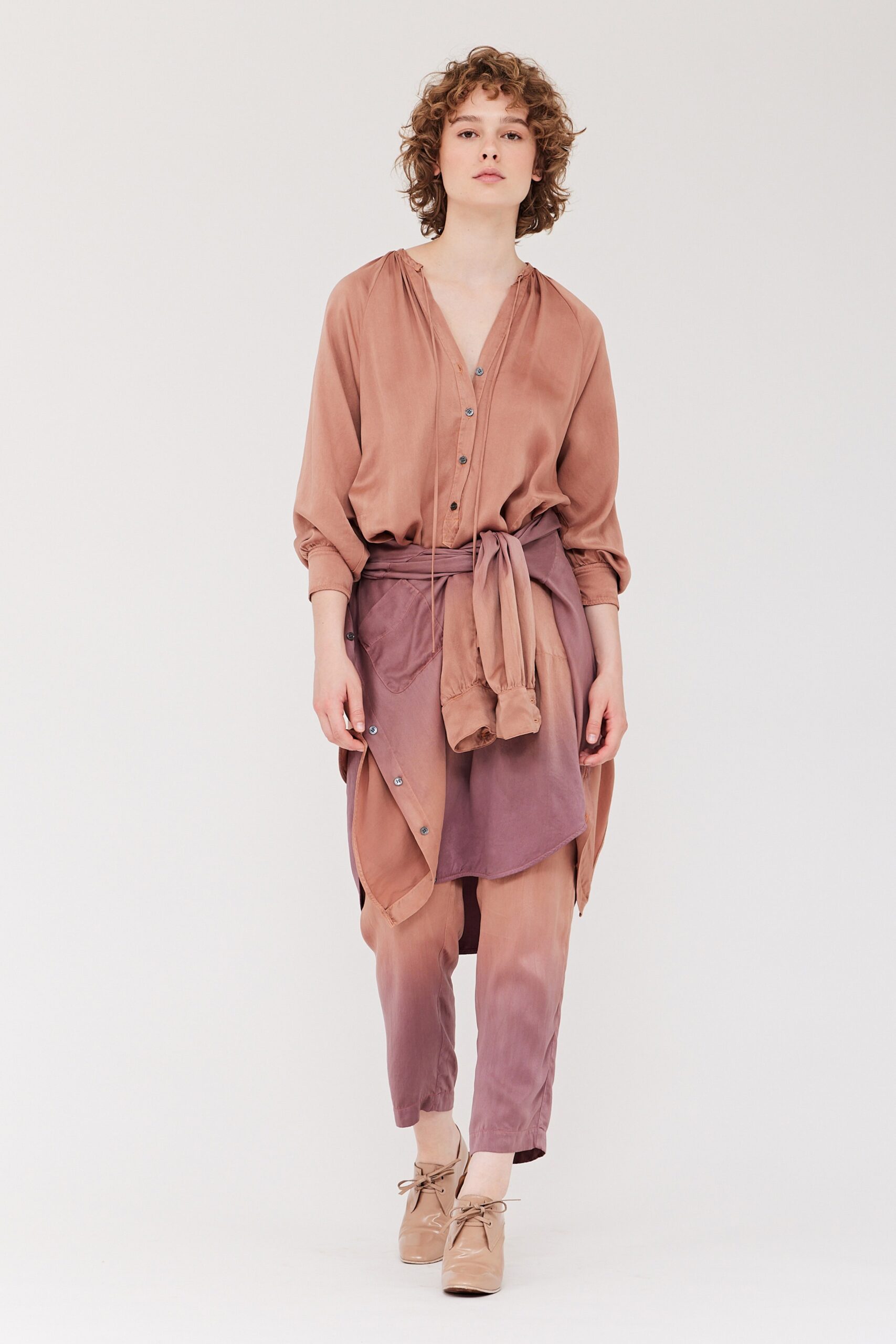 A relaxed brown silk shirt with long sleeves and layered pants for a chic look.