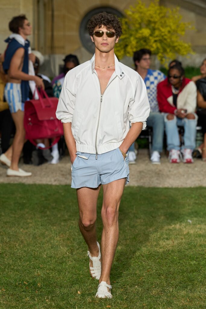 A fitted white cotton jacket with short sleeves paired with blue shorts.