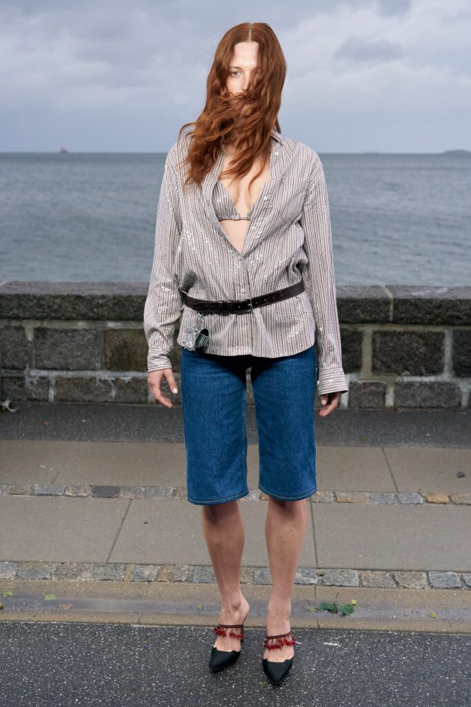 A relaxed long-sleeve striped shirt paired with blue denim shorts.