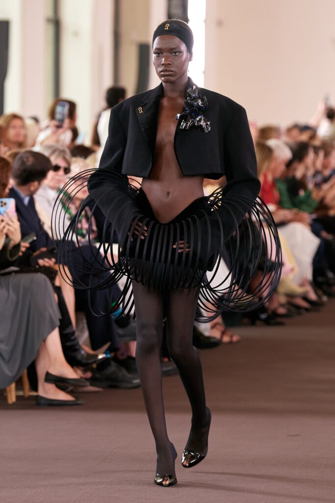 A fitted black jacket with an asymmetric layered skirt, showcasing a unique silhouette.