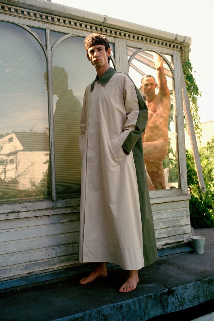 A relaxed beige and green coat with long sleeves and a collared design featuring an asymmetric detail.