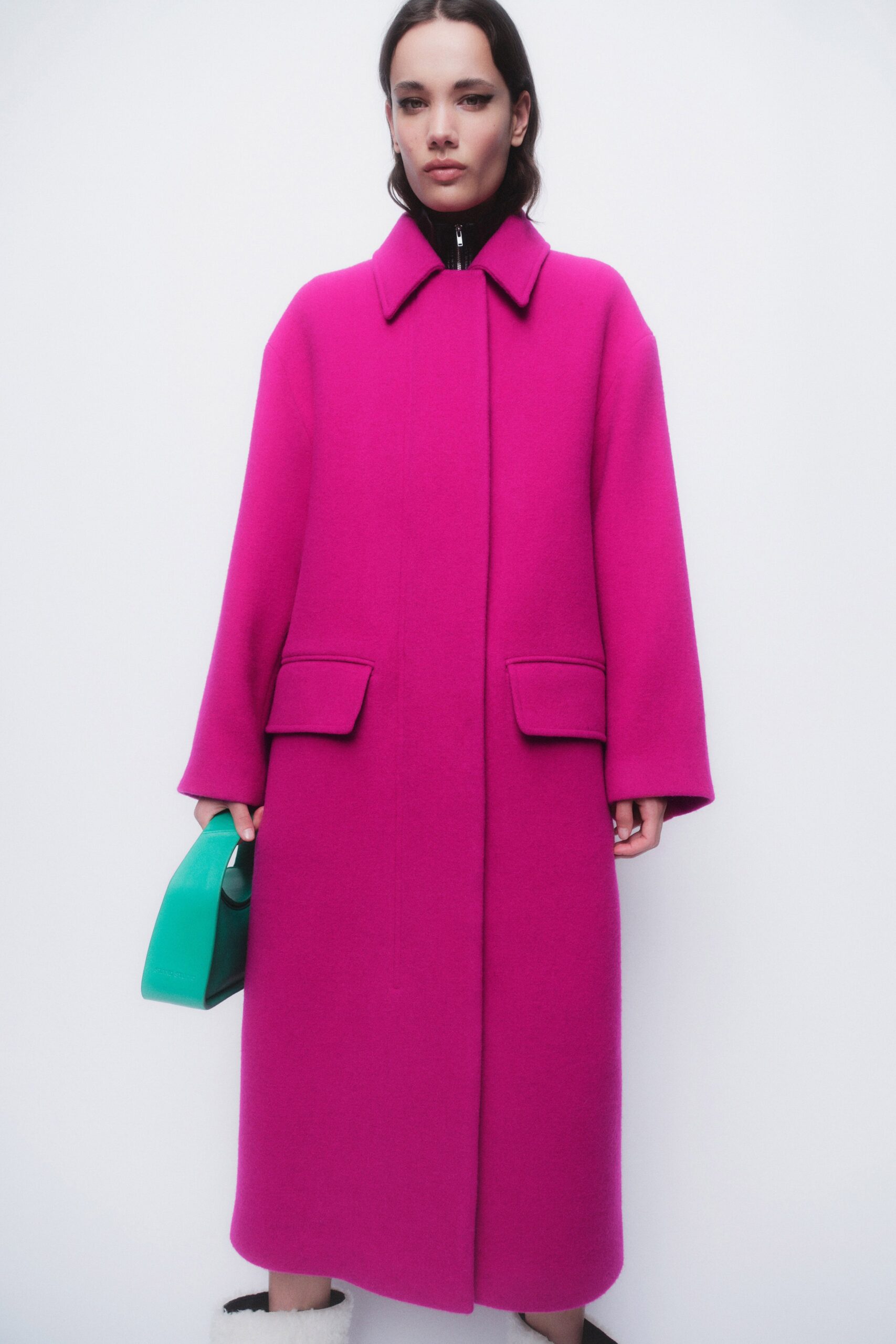 An oversized pink wool coat with long sleeves and a collared neckline.