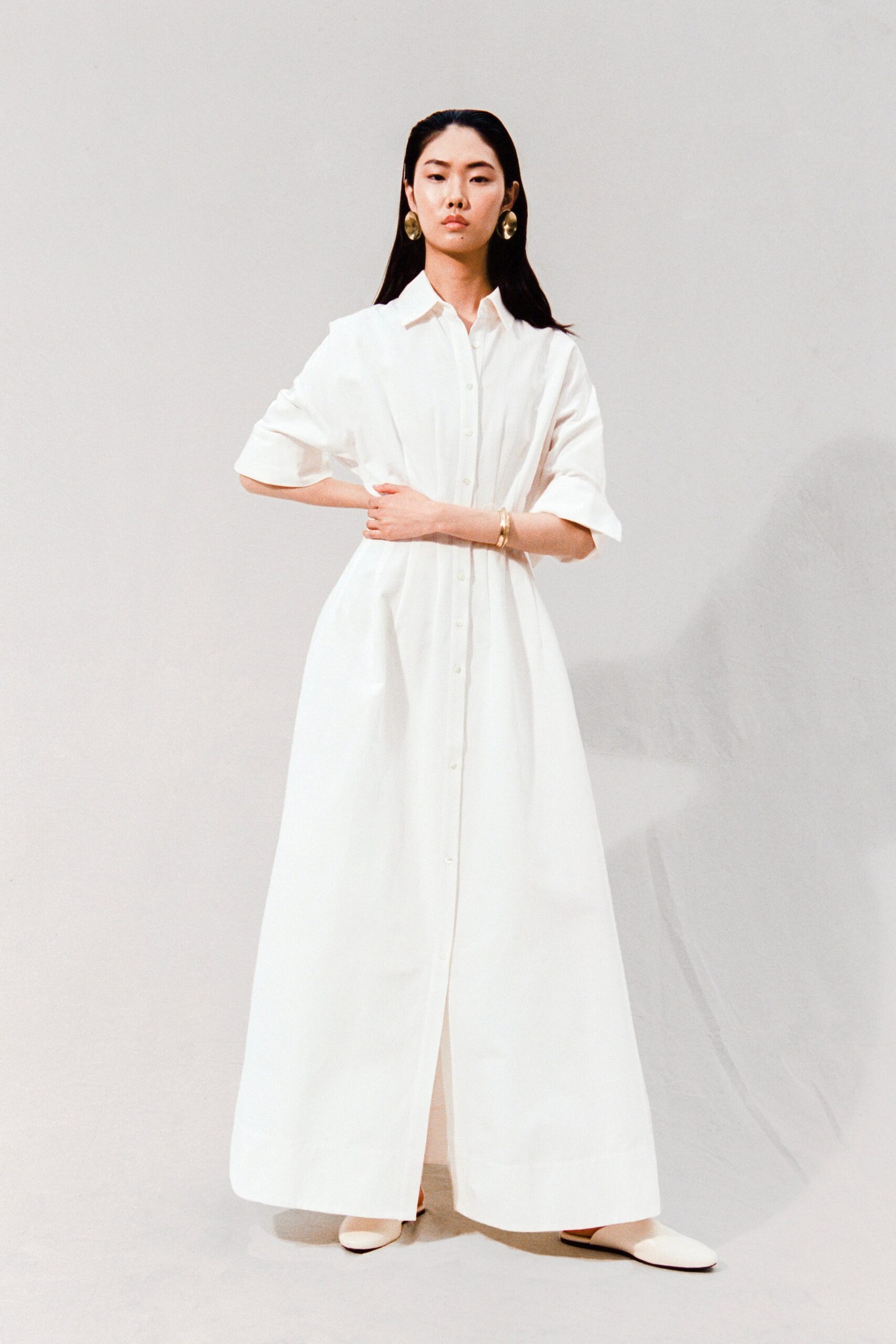 A relaxed white cotton short-sleeve dress with a collared neckline and maxi silhouette.
