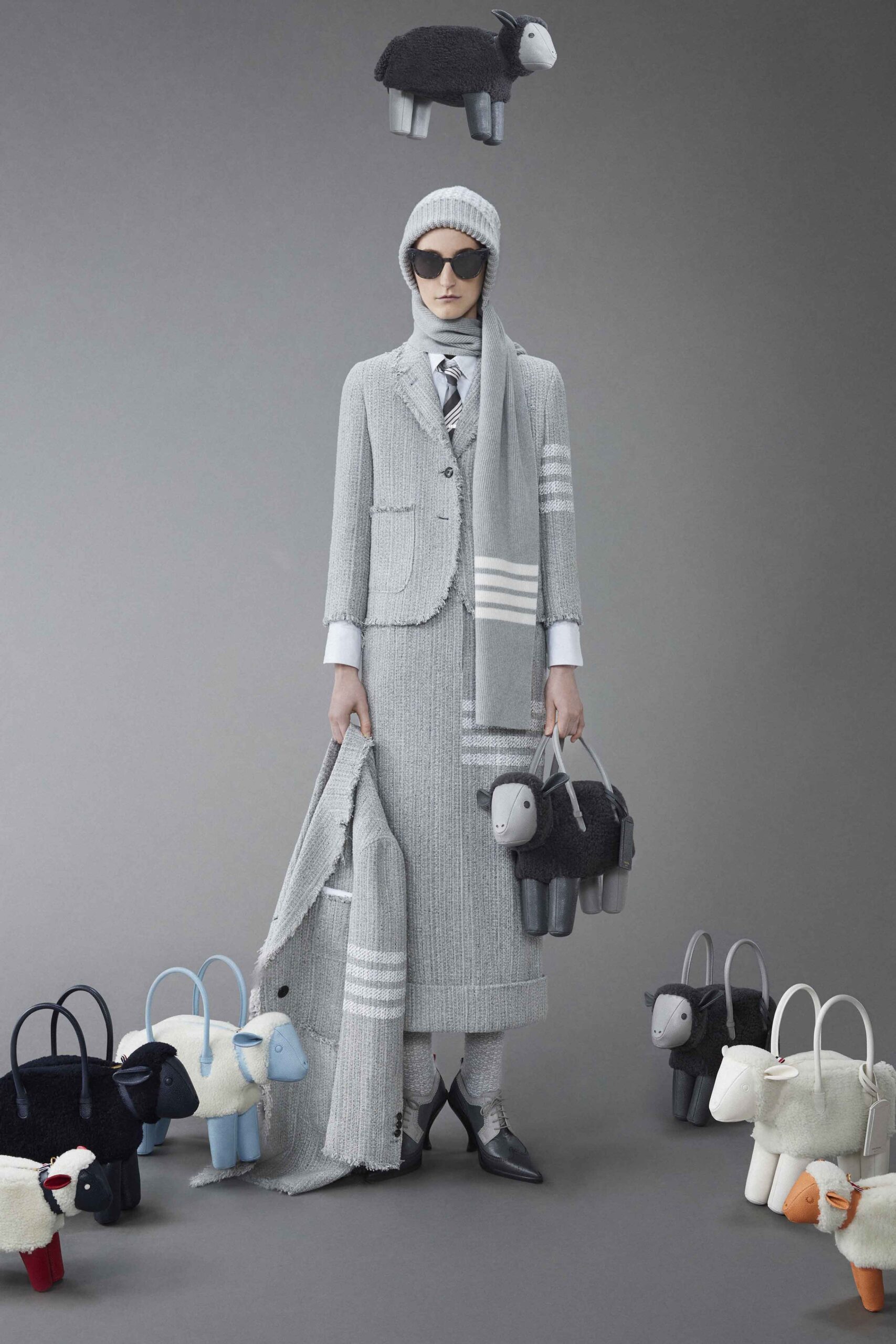 A fitted gray wool suit with long sleeves, a collared shirt, and a pencil skirt featuring stripes.