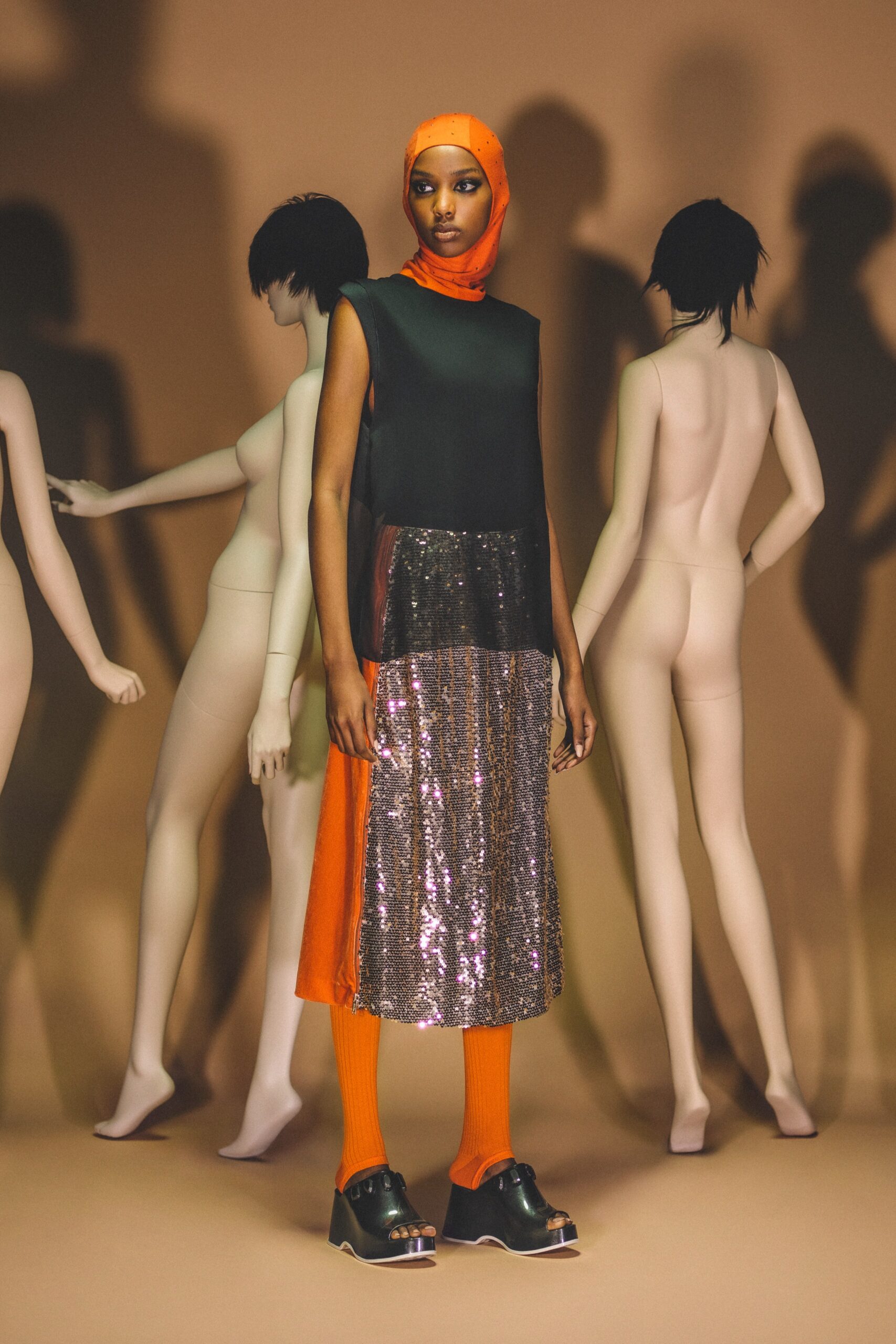 A relaxed black and orange sleeveless dress with a high neckline and layered design.