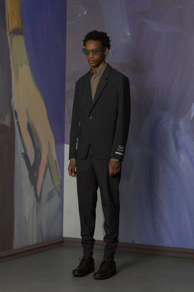 A tailored black suit with long sleeves and a collared shirt, featuring a straight-leg fit.