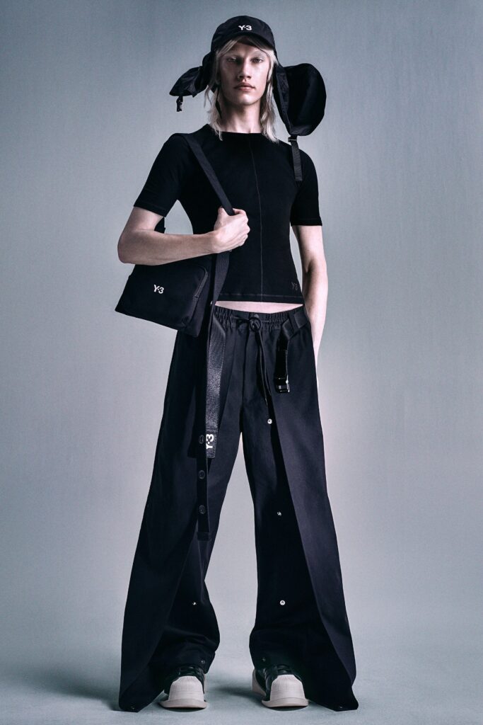 A fitted black cotton short-sleeve top paired with high-waisted wide-leg pants.