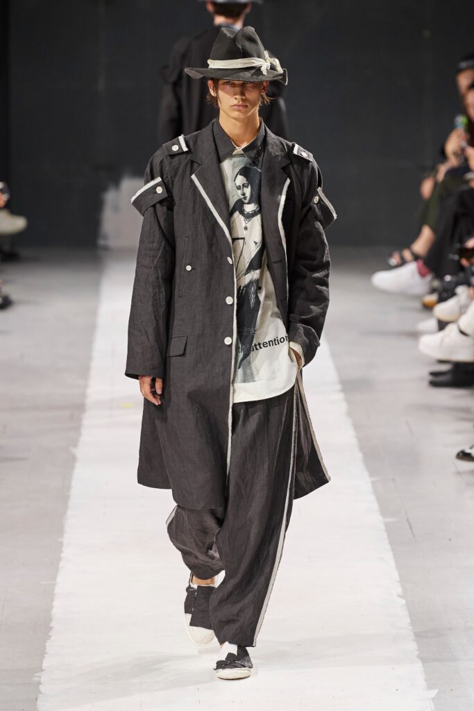 A relaxed black and gray coat paired with matching pants featuring a buttoned design and layered details.