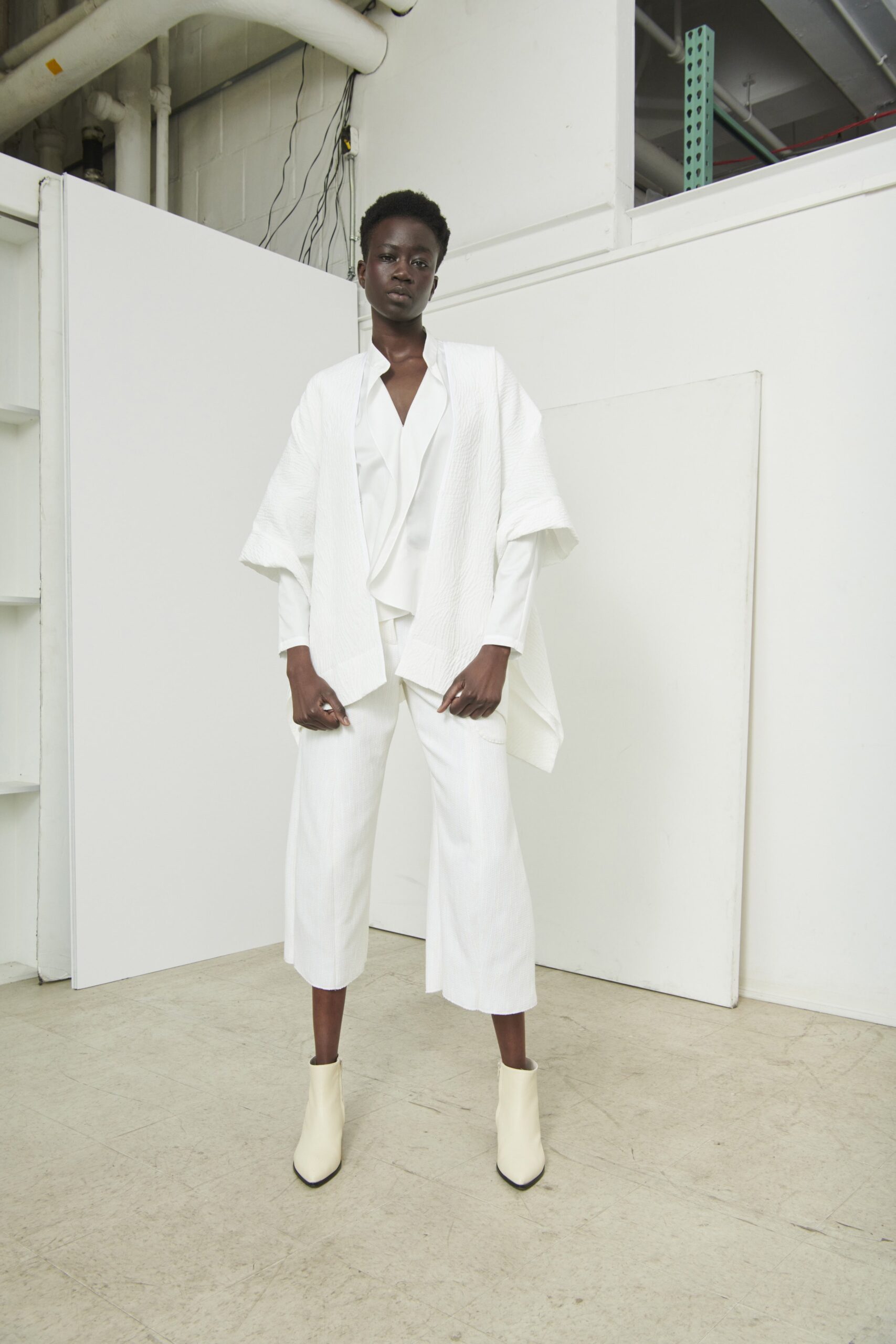 A relaxed white jacket with long sleeves and a collared design paired with matching pants.
