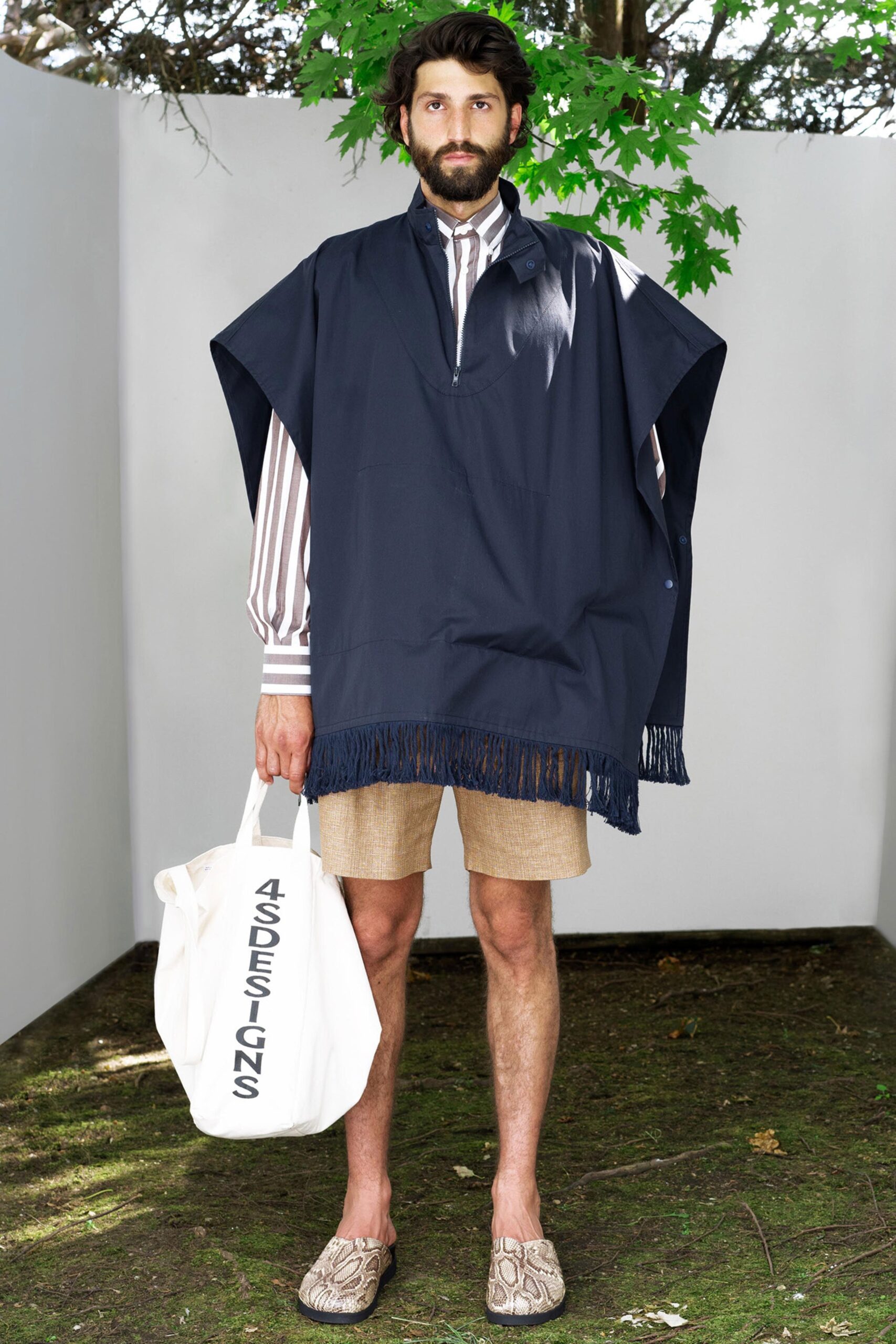 A relaxed navy cotton poncho with a collared neckline paired with beige shorts.