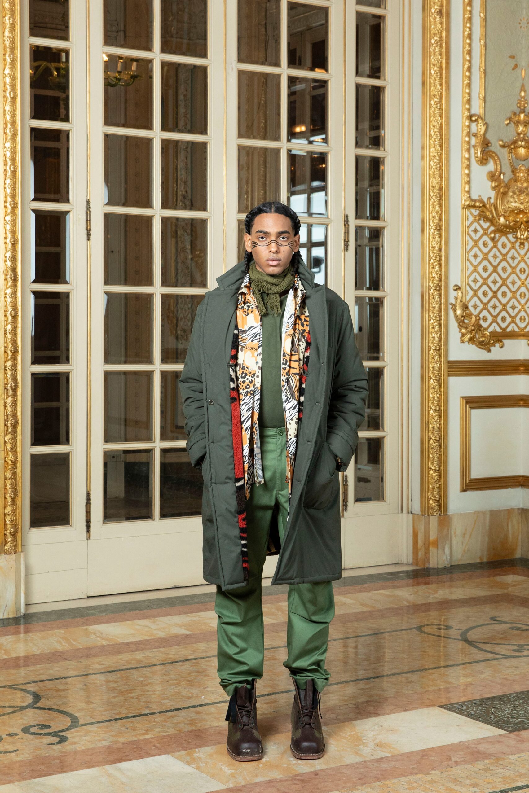 A relaxed green coat paired with matching pants, featuring a layered look and a collared design.