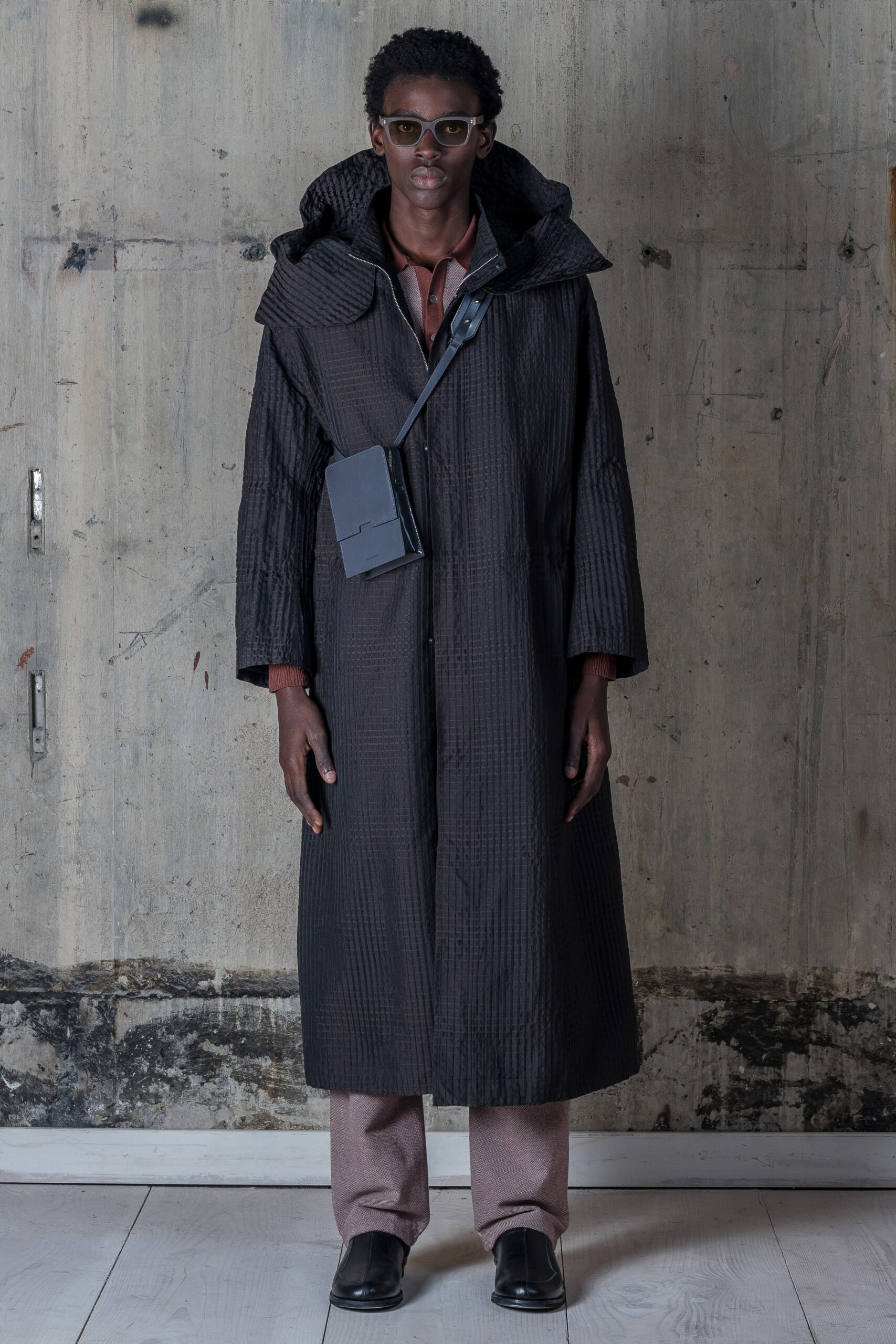 A relaxed black coat with a hood and zippered detail, perfect for layering.