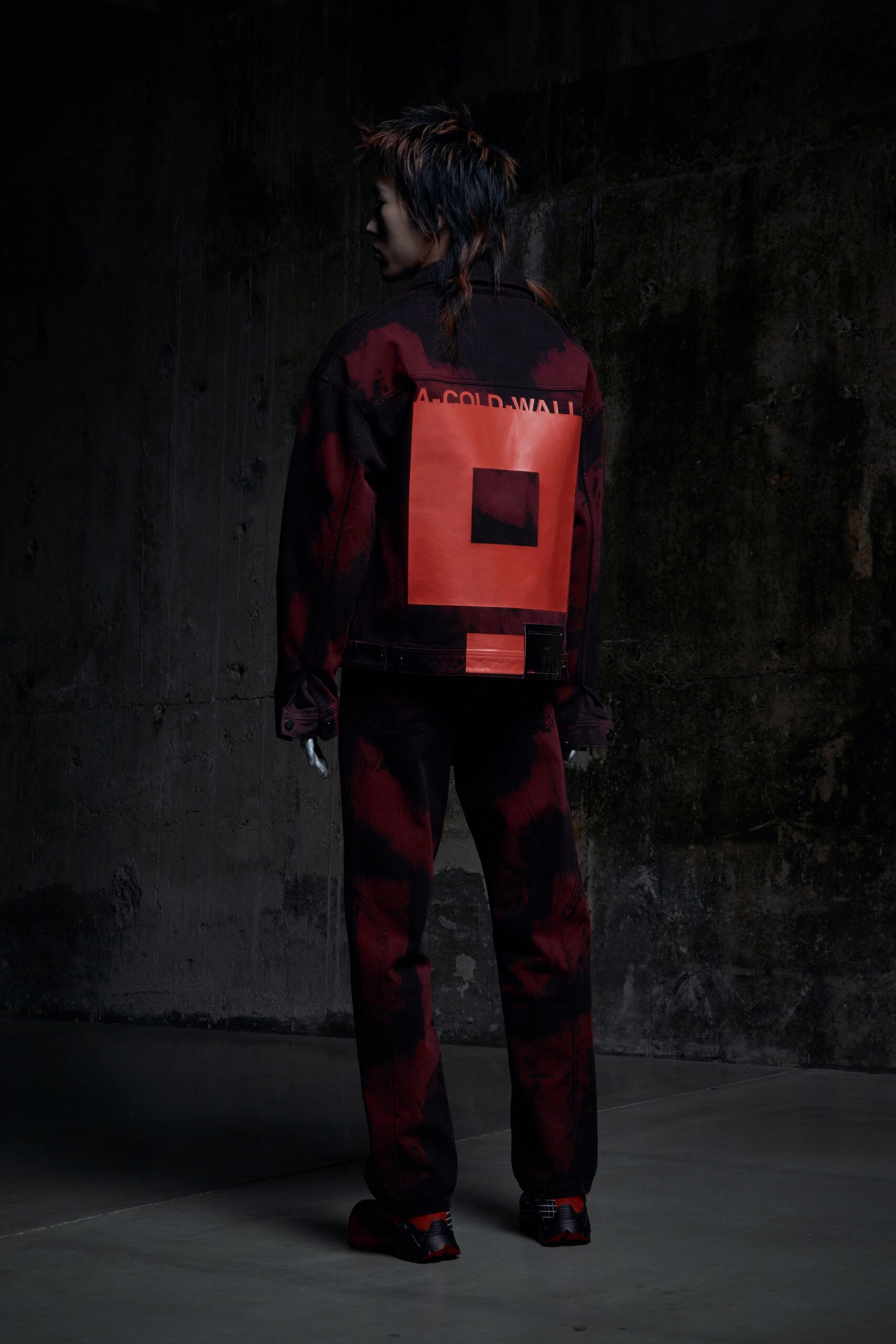 A relaxed black and red denim jacket with long sleeves and printed design, paired with matching pants.