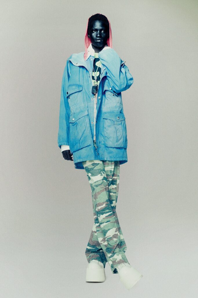 A relaxed blue jacket paired with camouflage pants, featuring a collared design and long sleeves.