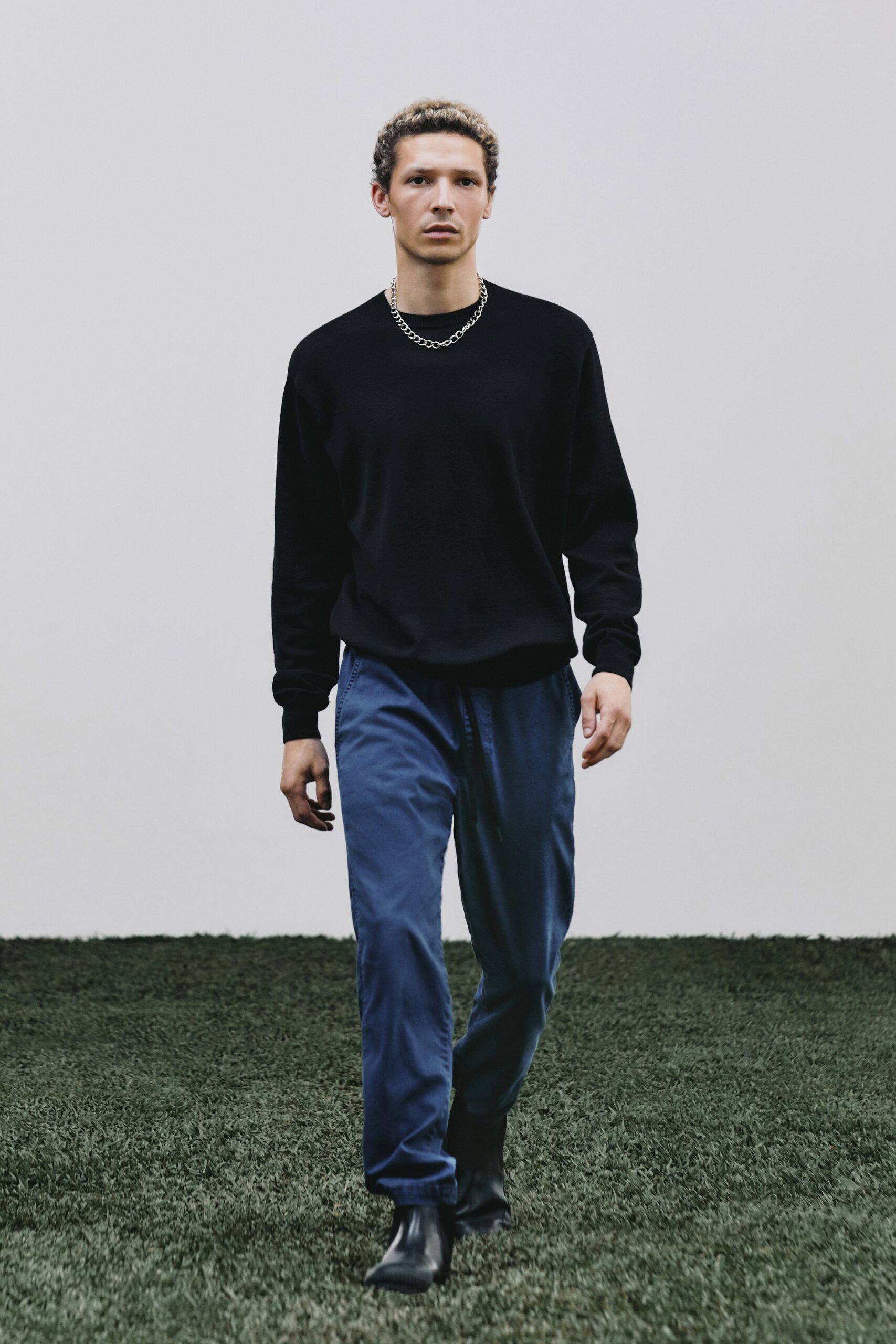 black relaxed sweater with blue pants
