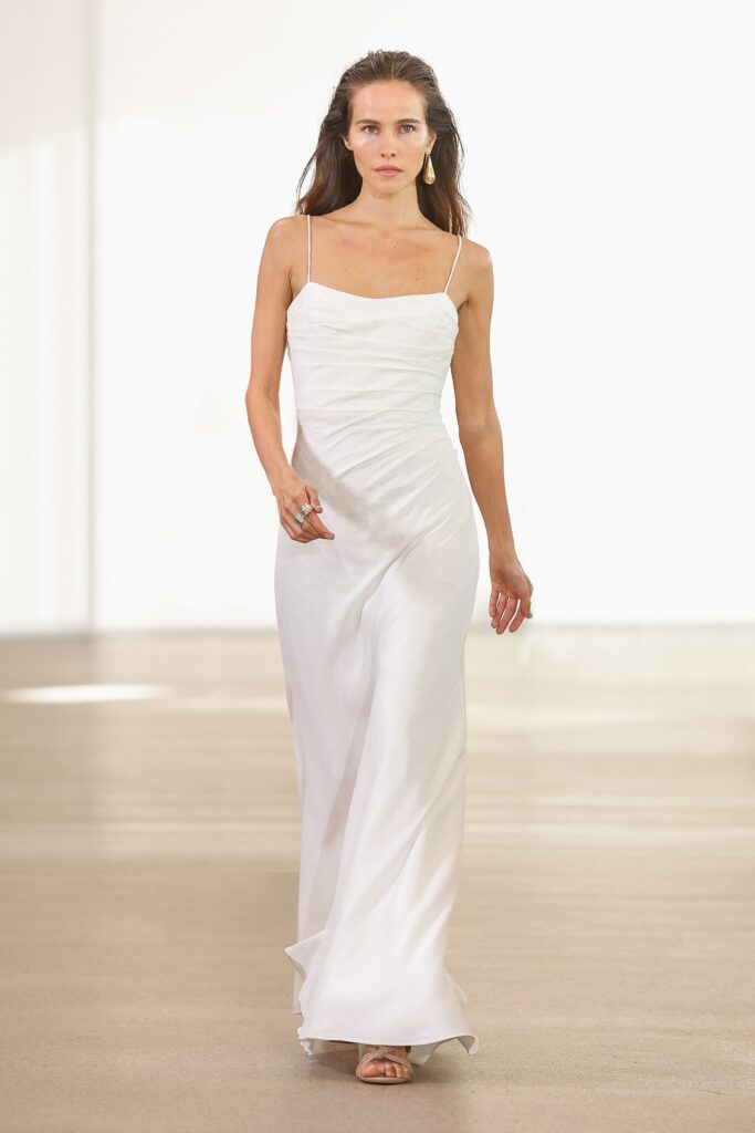 A fitted white silk dress with a sleeveless design and V-neckline.