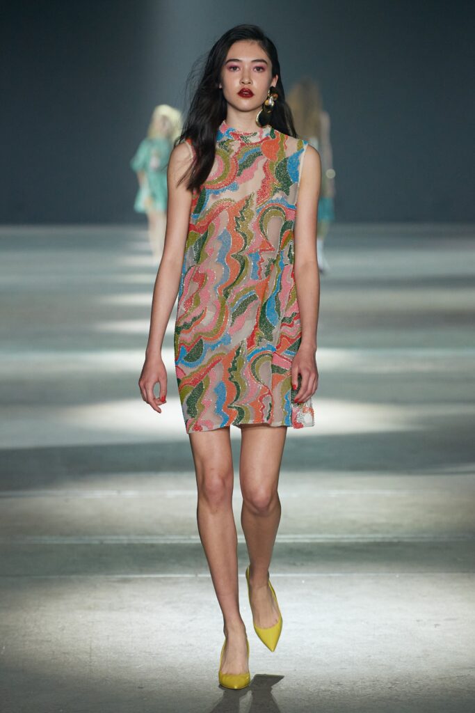 A fitted multicolor silk sleeveless dress with a high neckline and printed design.