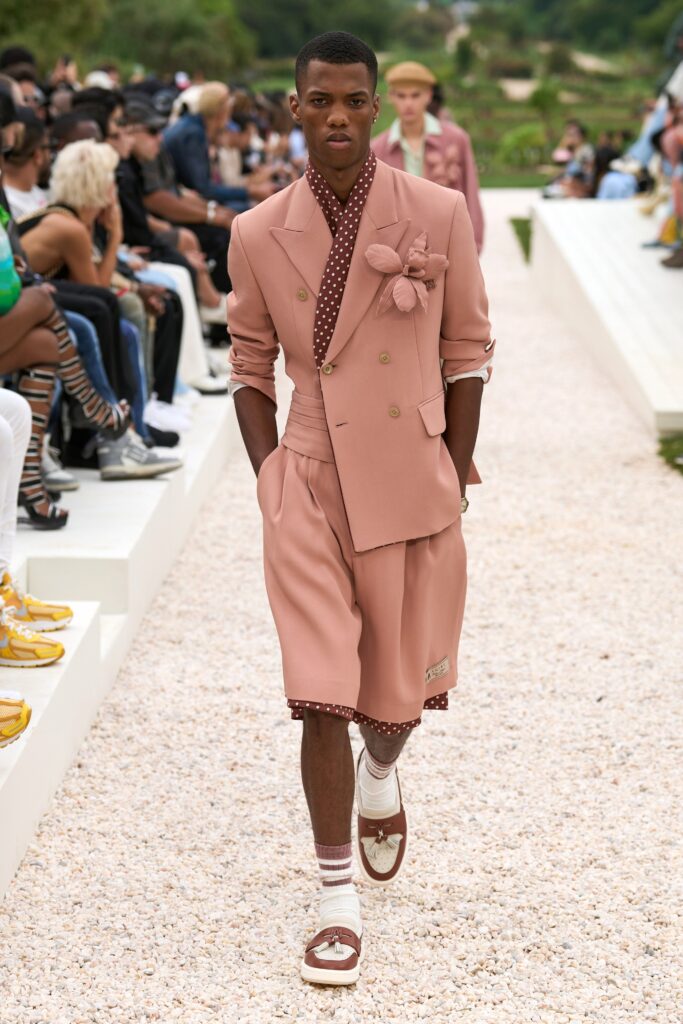 A fitted pink suit featuring a collared short-sleeve jacket and matching shorts.