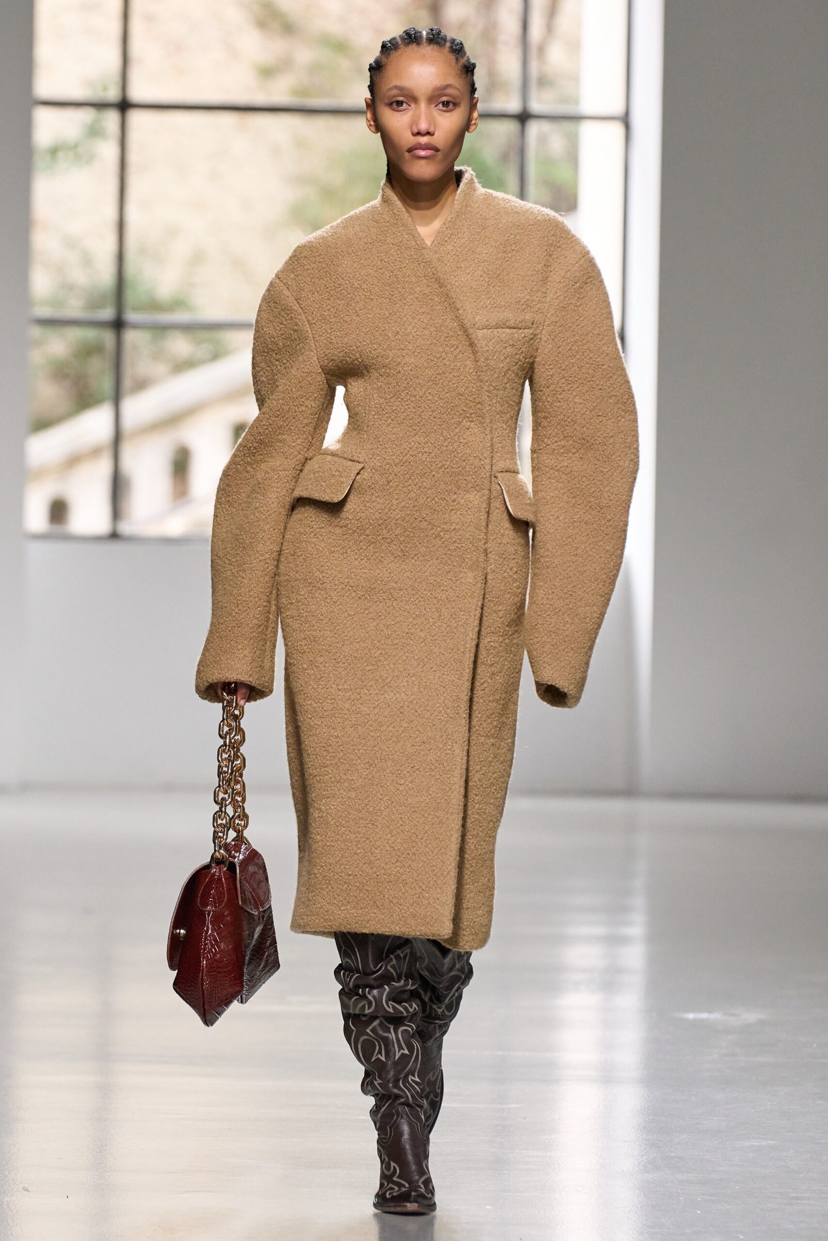 An oversized beige wool coat with long sleeves and a structured design.