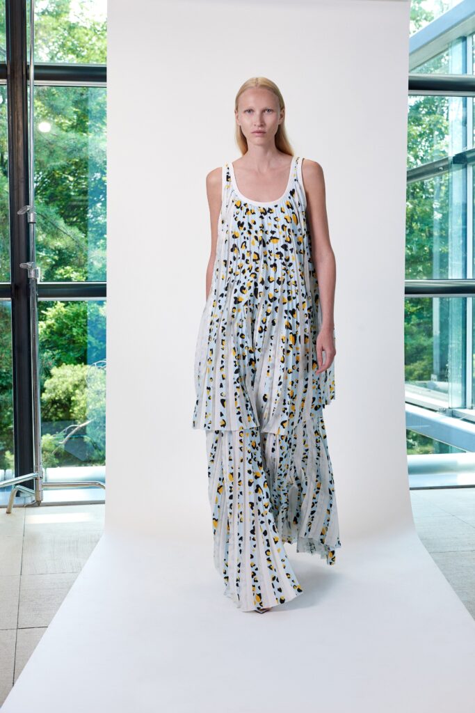 A relaxed fit sleeveless dress in white with multicolor tiered design.