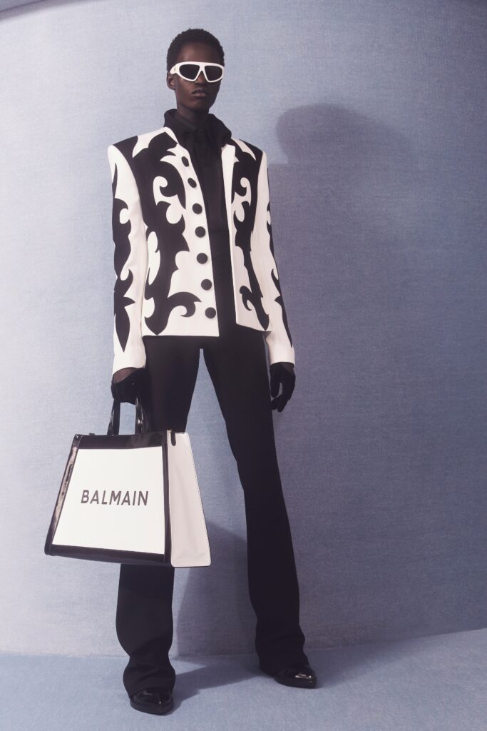A tailored black and white buttoned jacket paired with sleek black pants.