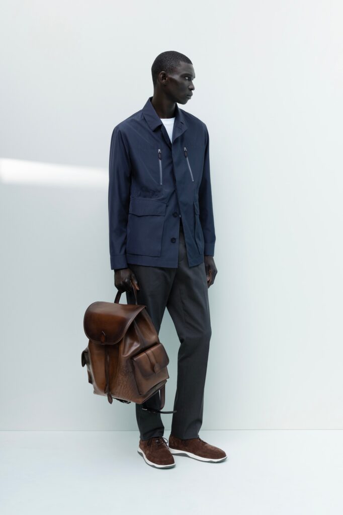 A relaxed blue cotton jacket with long sleeves, collared design, paired with gray pants.