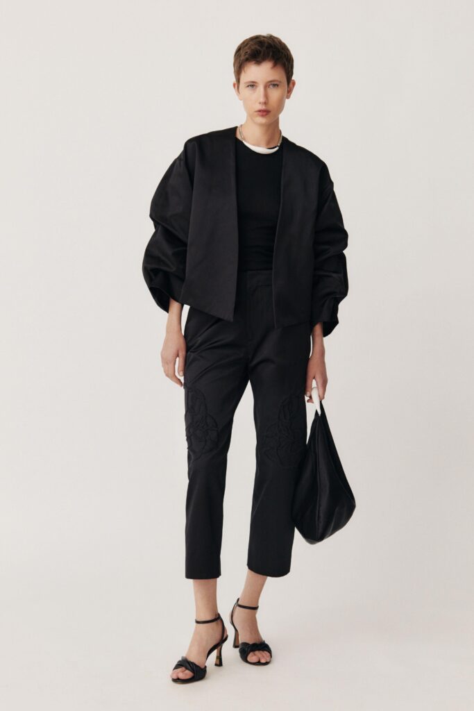 A fitted black cotton jacket with long sleeves and embroidered pants for a chic look.