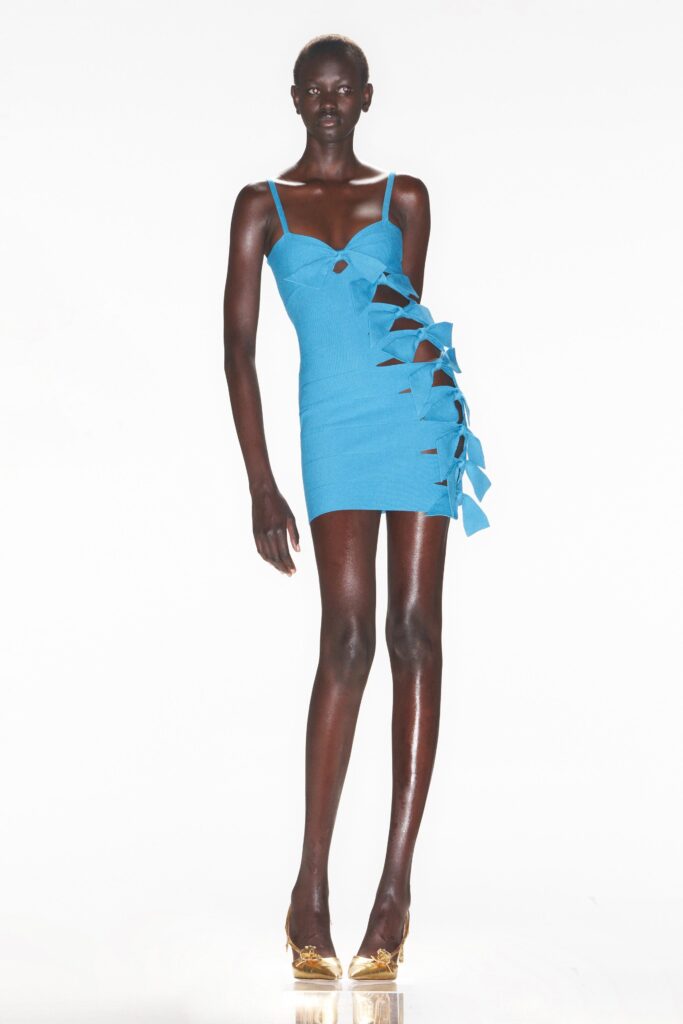 A fitted blue sleeveless dress with a V-neckline and asymmetric design details.