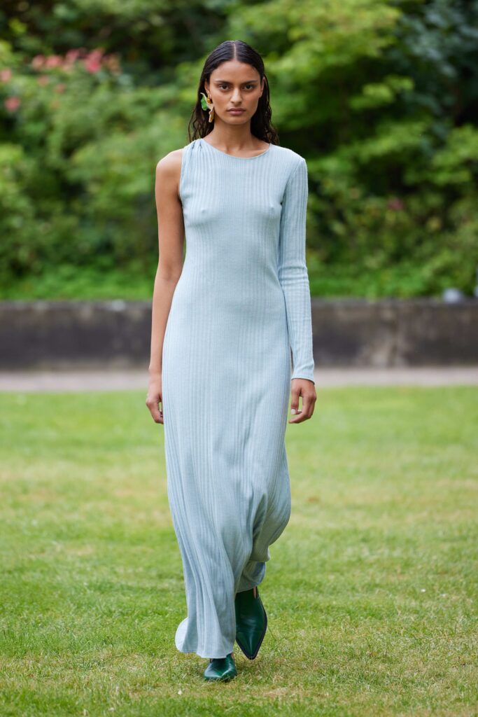 A fitted blue cotton long-sleeve dress with a sleek silhouette and elegant design.