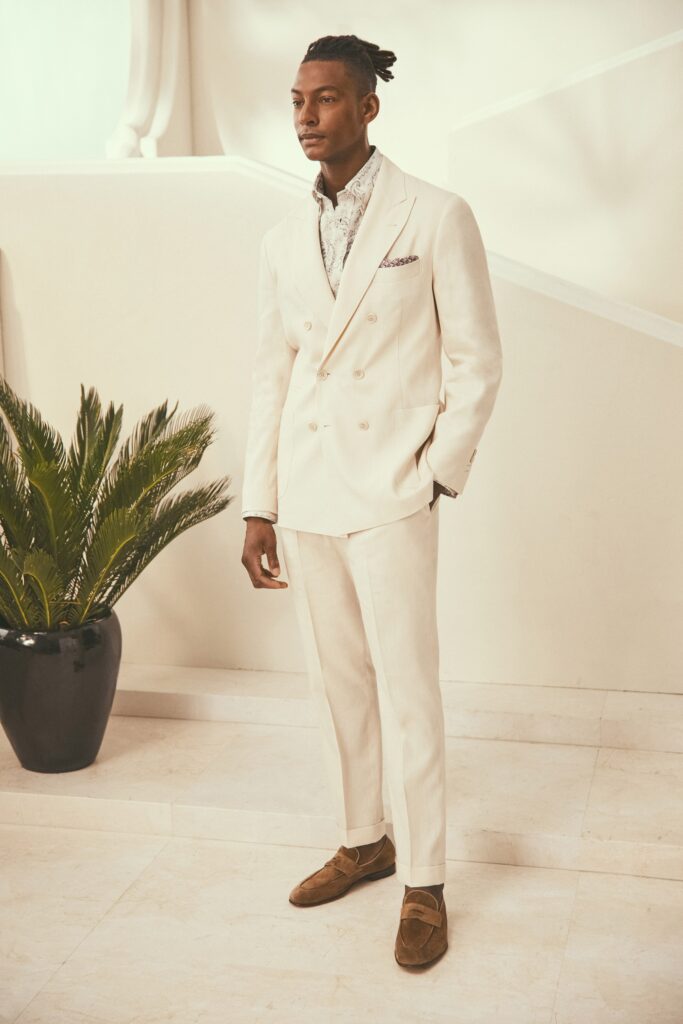 A tailored white suit with a collared long-sleeve shirt and buttoned details.