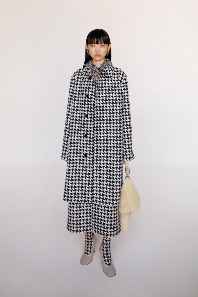 A relaxed black and white checked coat dress with long sleeves and a collared neckline.