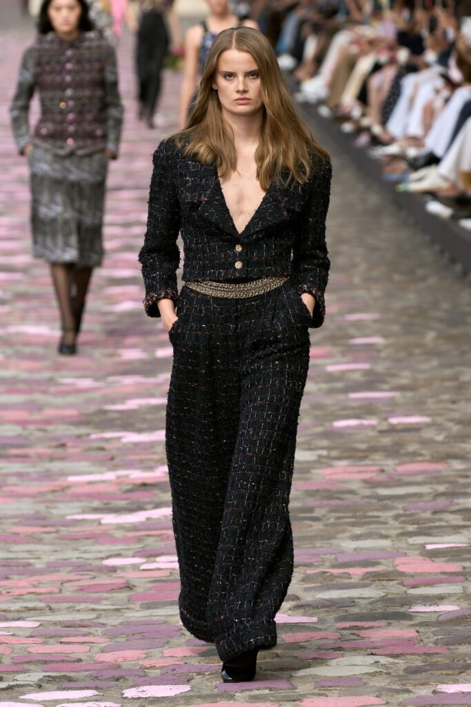A tailored black tweed suit with a V-neckline and wide-leg trousers.
