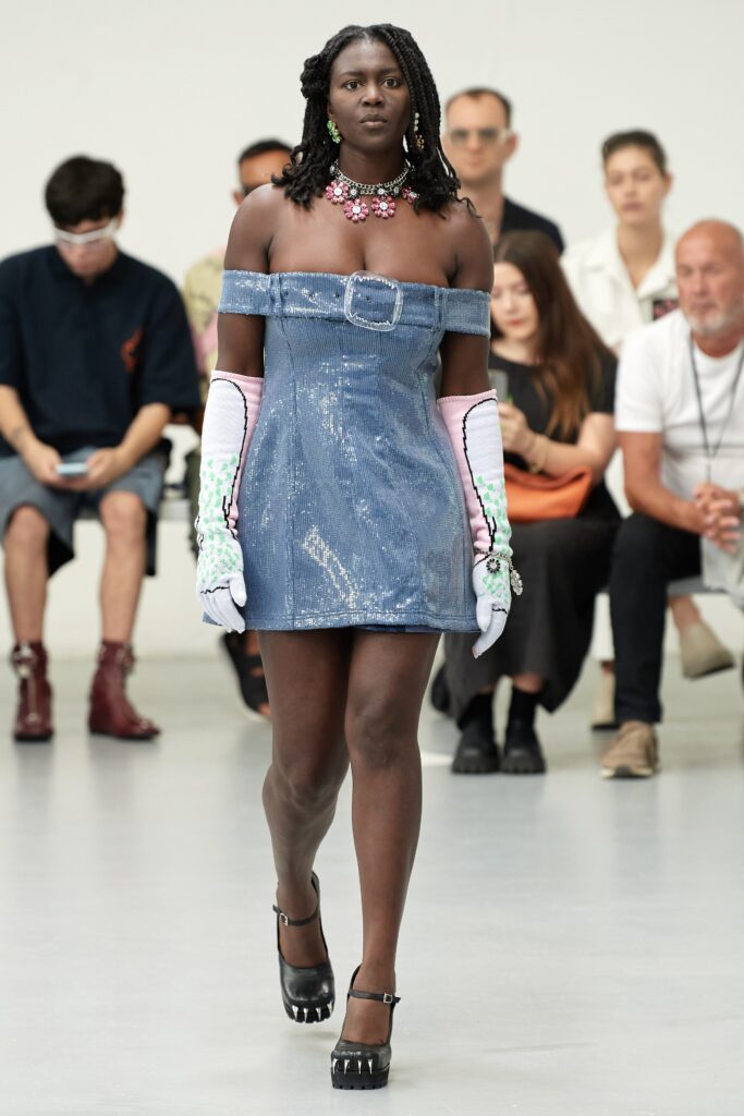 A fitted blue denim mini dress with an off-shoulder design.