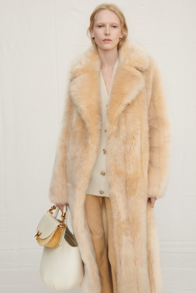 An oversized beige fur coat with a collared design and layered look.