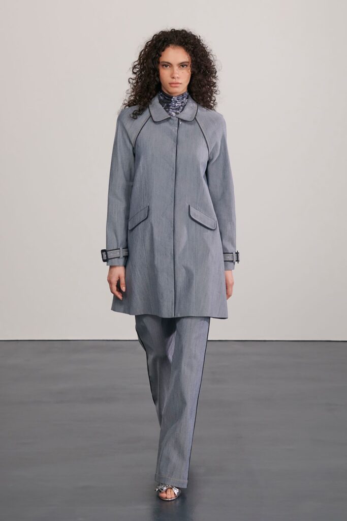 A relaxed gray cotton coat with long sleeves and a collared neckline, paired with straight-leg pants.