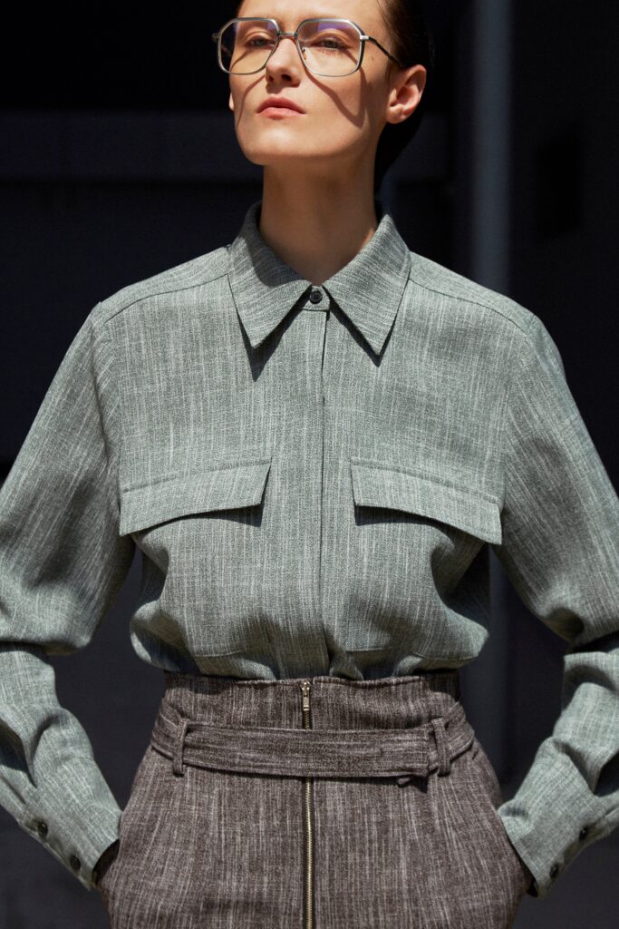 A fitted gray cotton long-sleeve shirt with a collared neckline paired with straight-leg pants.