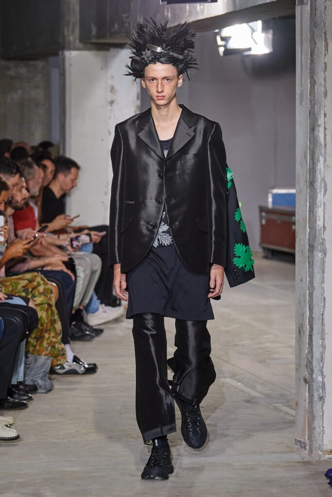 A relaxed black silk blazer with long sleeves and asymmetric design paired with matching pants.