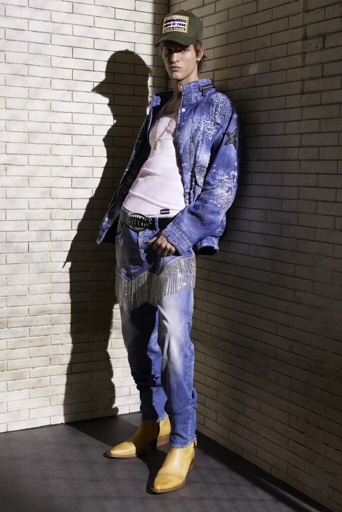 An oversized blue denim jacket paired with fringed blue pants and yellow boots.