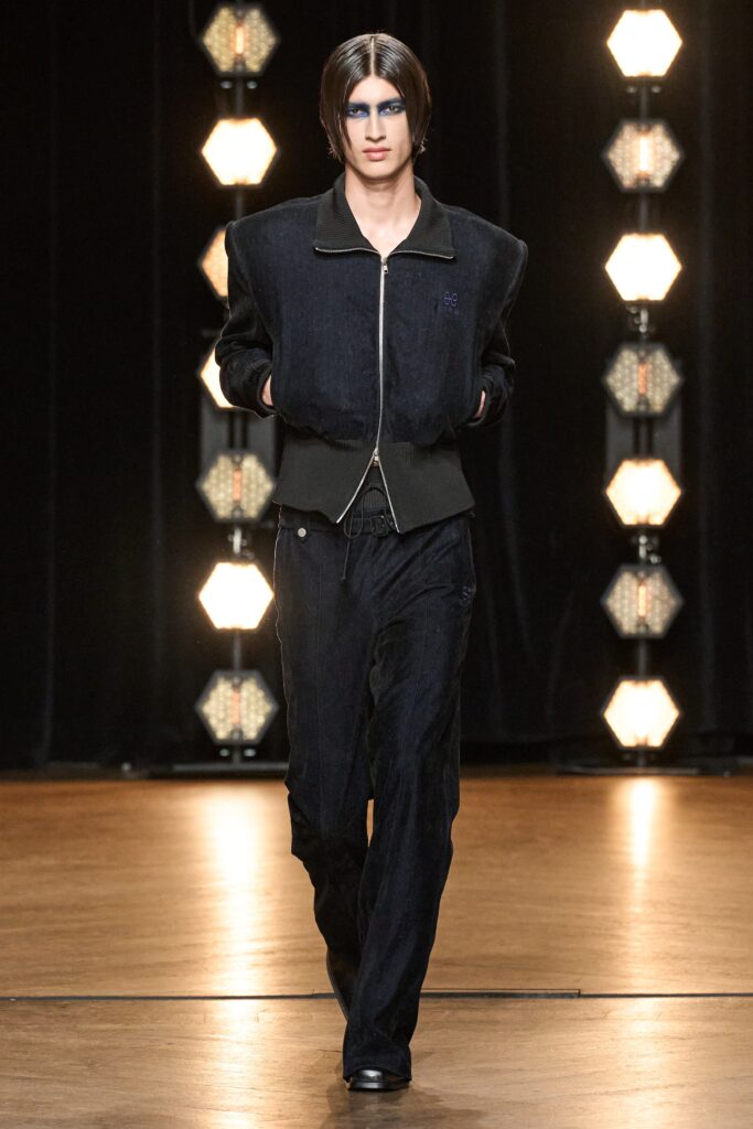 A relaxed black denim jacket with long sleeves and matching pants featuring a zippered detail.